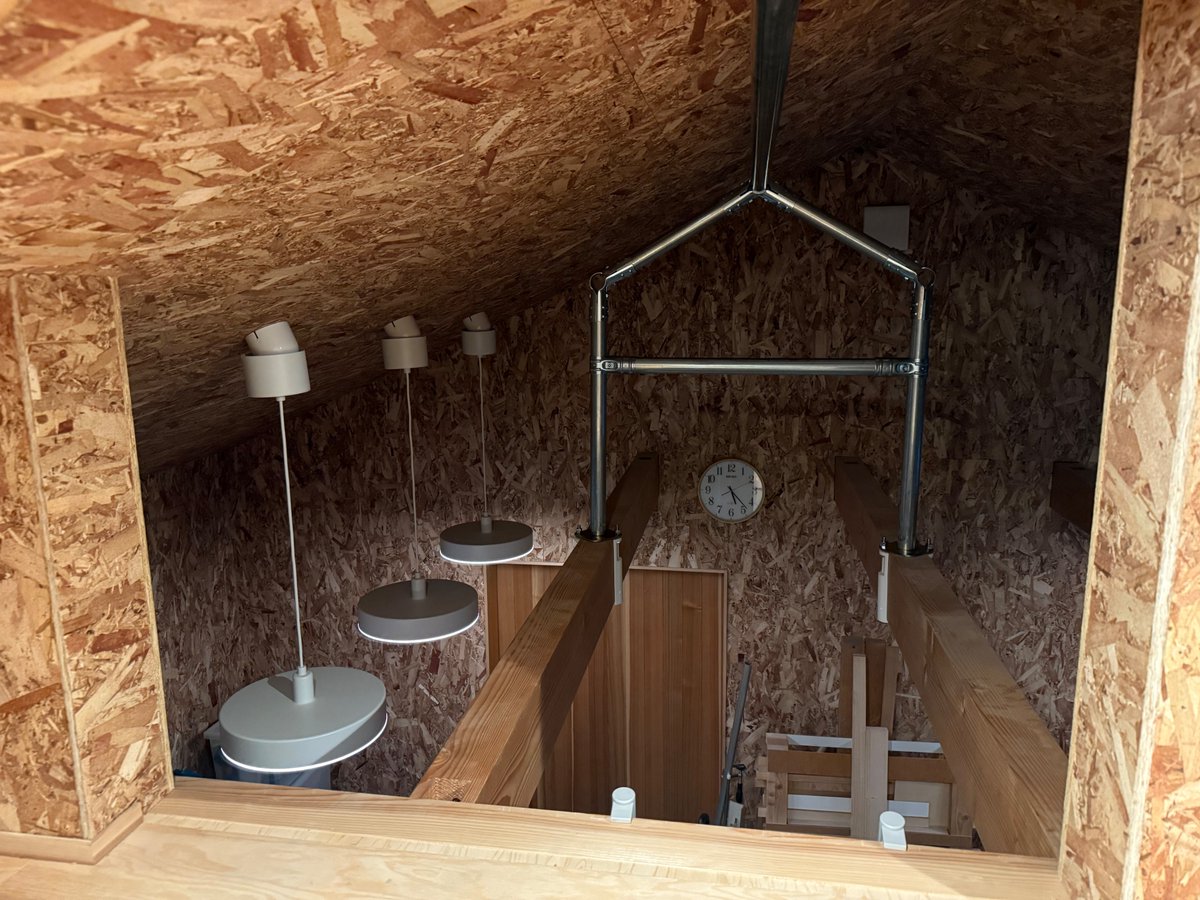 玄関ポーチ天井裏の物置スペースは約3mの自作ハシゴでしか出入りできないので、大きな荷物が収納できないのが悩みでしたが、単管パイプとNTYパイプジョイントで電動ホイストをぶら下げるレールを組み立てました。これでキャンプ道具みたいな大物も格納できる！1人だけで組み立てるの苦労しました。