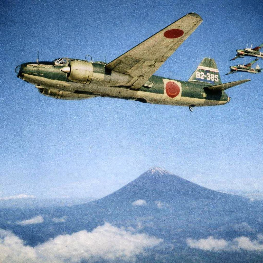 A formation of G4M1 Model 11 bombers of Japanese 701st Naval Air Group in flight with a mountain in the background, circa 1940s