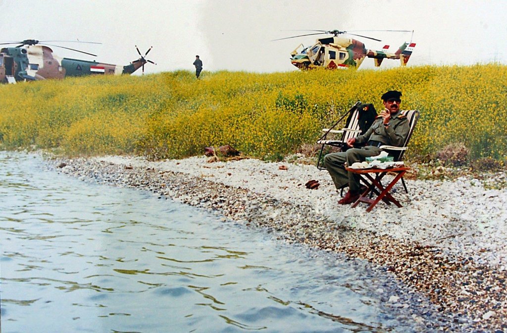 Saddam Hussein smoking a cigar on the banks of the Tigris with a Messerschmitt-Bölkow-Blohm BK 117 A-1 and a Agusta-Sikorsky ASH-3D/TS Sea King behind him at an unknown date.
Copy of the photograph was found in one of Saddam Hussein's residences in Baghdad on April 19th, 2003.