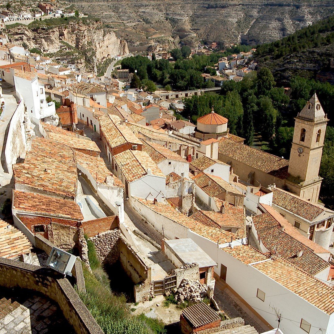Where the #JúcarRiver carves its way through the wild cliffs of #Albacete, the whitewashed beauty of #AlcaláDelJúcar rises above the canyon like a dream. Terracotta rooftops, winding streets, and nature in perfect harmony. 🌿