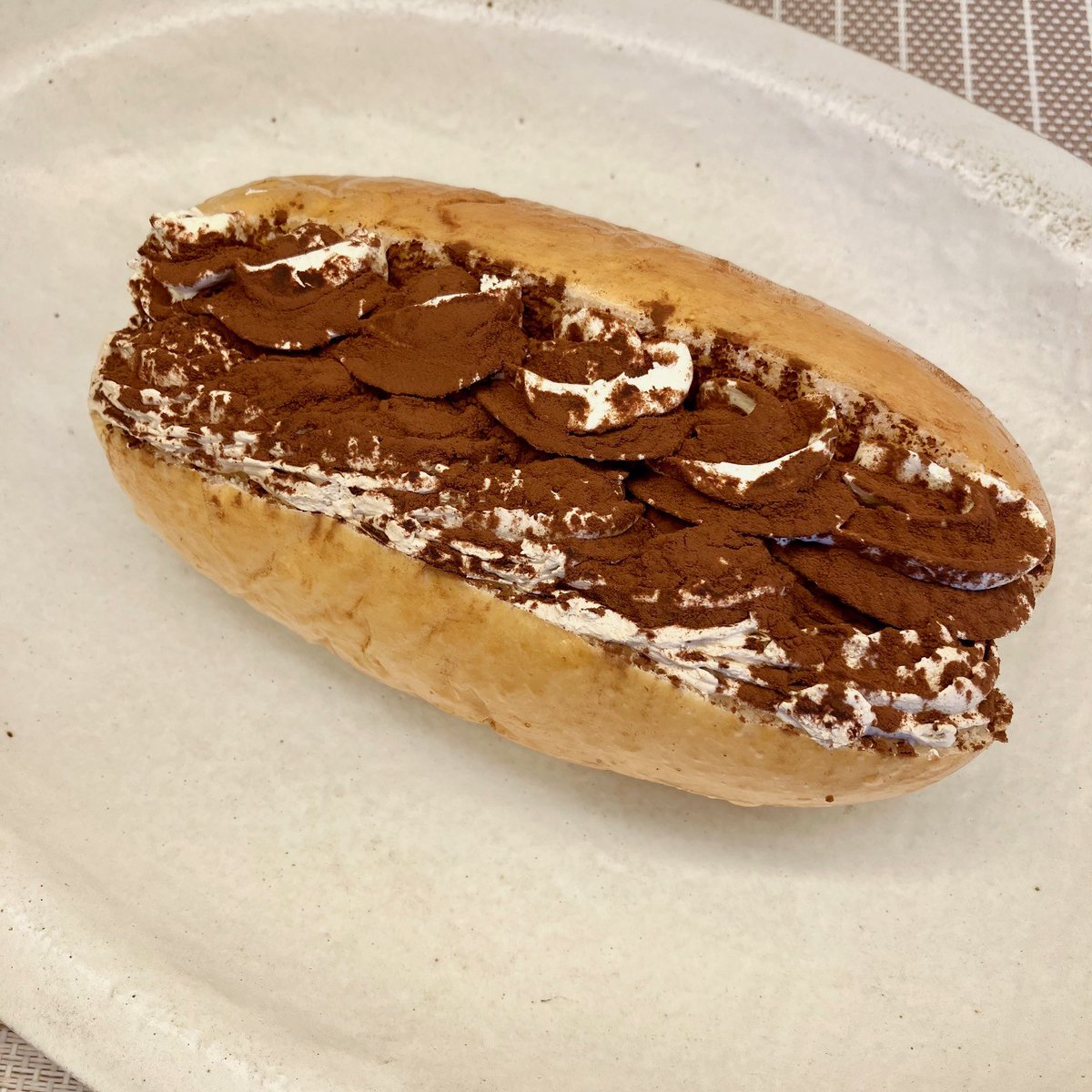 ティラミス

ふわふわのコッペパンに、コーヒー、マスカルポーネチーズの2種のホイップクリームを絞り、ココアパウダーを振りかけています。あっさりクリームにココアのほろ苦さがベストマッチ。女性に大人気のデザート系です。

wkobe.jp/bread/20260222/

＃本日のパン