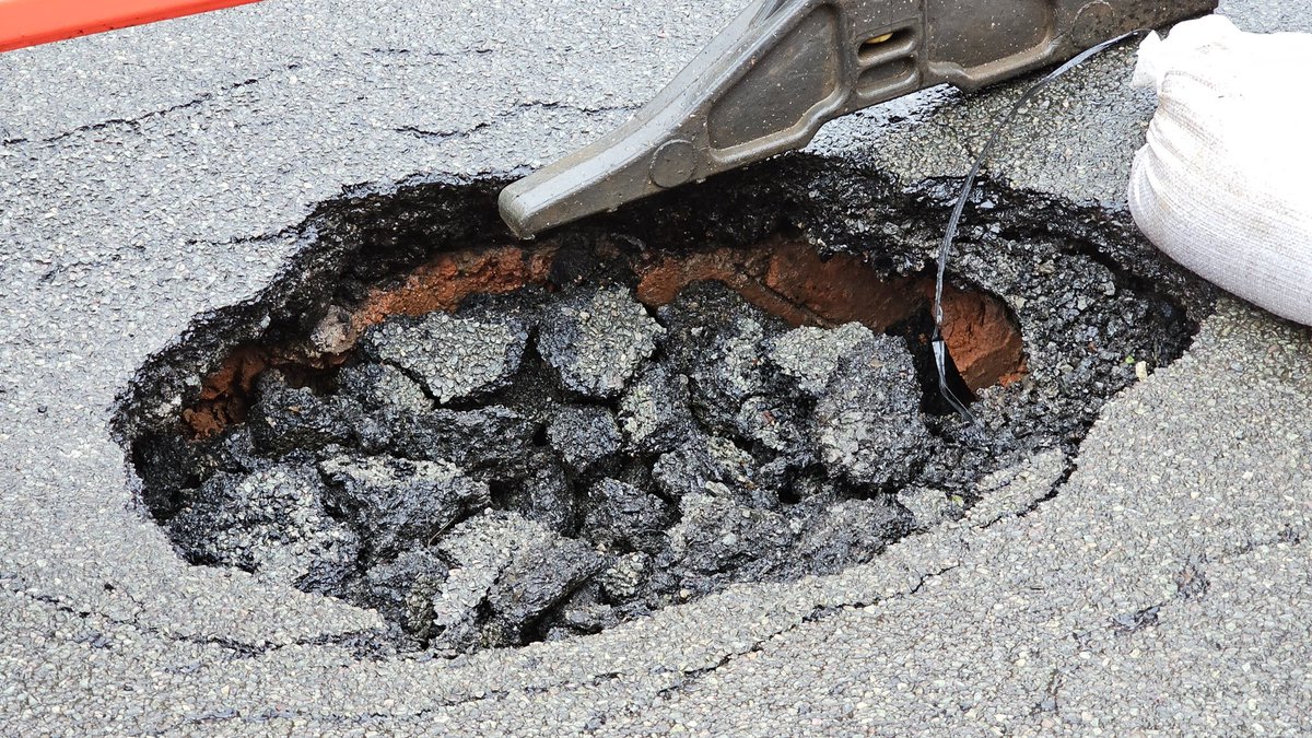 Cute little hole in our road. You can just make out some diagonal bricks in the back.