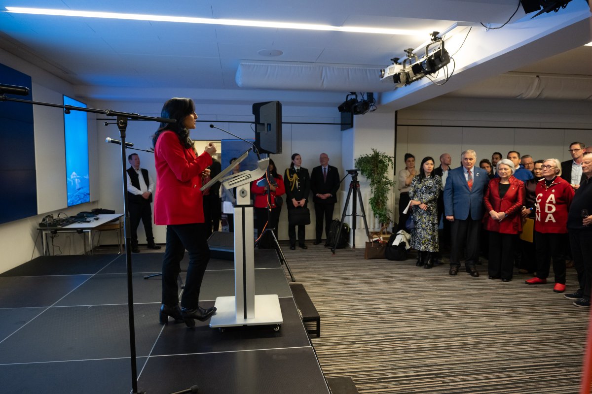 La ministre Anand, debout derrière un podium, s'adresse aux invités qui assistent à la cérémonie d'ouverture du nouveau consulat du Canada à Nuuk, au Groenland.