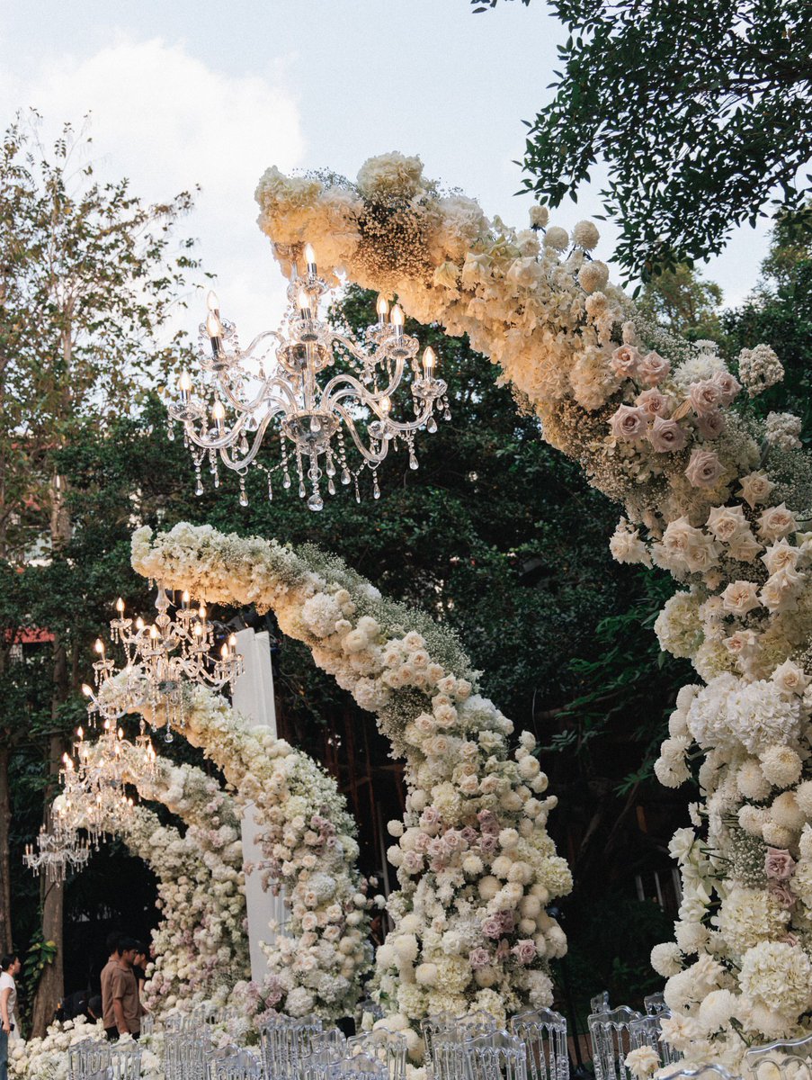 ㅤ
Angin laut berembus pelan, membawa aroma garam yang segar dan wangi bunga kamboja disertai mawar putih yang menenangkan, menyisir satu persatu area taman luas yang tertata presisi seindah mungkin hampir samanya dengan sepasang suami istri yang berbahagia pada hari ini. 

ㅤ