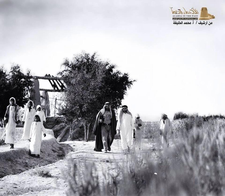 المصور جوزيف ماونتن ورفيقه يلبسان ثياب أهل الأحساء ويتجولان في حقل لزراعة الحبوب 1935م