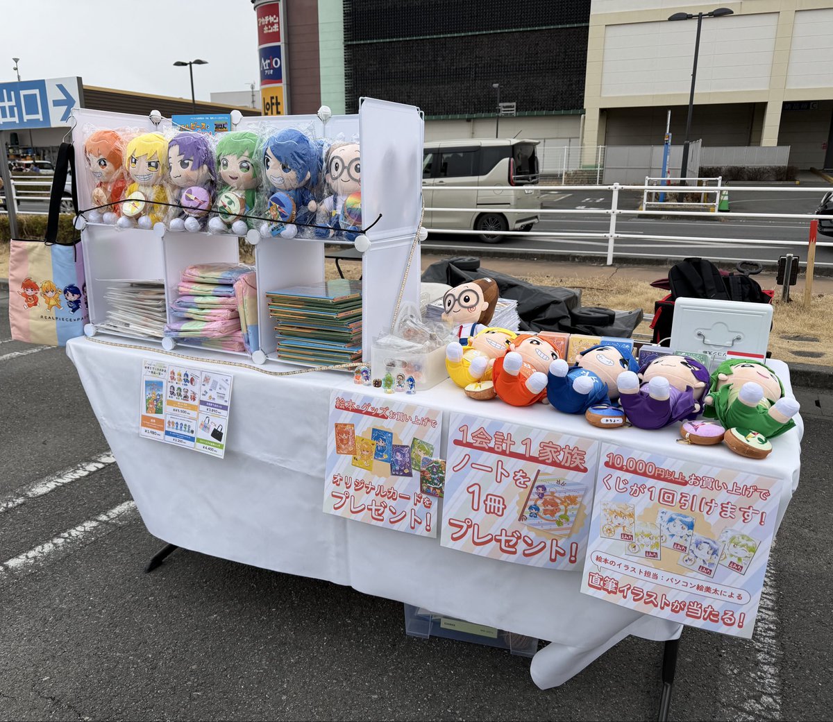 realpiece_pct's tweet photo. 本日2026.2/7アリオ上尾リアルピースさんフリーライブ会場にて
リアルピースとぱそこんたろう〜5つのらしんばん〜絵本とグッズを販売させていただきました♫

雪がちらつき、冷たい風の中ご参加されました、りあぴぞくの皆様ありがとうございました☺️あたたかくして風邪などひかないようにお気をつけくださいね🛀🍵💖

ブースでは、朝から強風が続きテントがたてられず、テーブルのみで販売を開始いたしました。あまりの寒さに、ヤツルギ魂様にご相談して風よけに車をすぐ横へ置かせていただきました。背が低い車のためあまり風よけとはいかなかったのですが、そこはただでは終わらせません笑
せっかくなので展示用に急きょ活用いたしました♫
テント用に作ってきたPOPがピッタリで😆いい感じに飾り付けできたのではないかと思います♫

ブースまで来ていただいたりあぴぞくの皆様、絵本を愛読していただいてる皆様本当本当にありがとうございます🥰

#リアルピース
#パソコン太郎
#リアピ絵本

@paso_taro