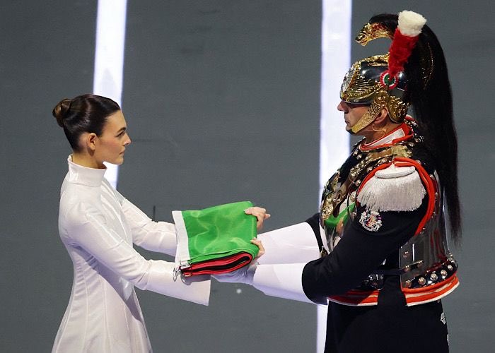 AvvRossello's tweet photo. Consegna bandiera olimpica: giovane  donna in bianco e corazziere. Le due sagome ci mostrano che, anche nella modernità e nella velocità dei tempi odierni, è possibile mantenere intatta dignità, compostezza e bellezza di un Paese che muta senza mai perdere le proprie radici. https://t.co/EcCxec7RZ9