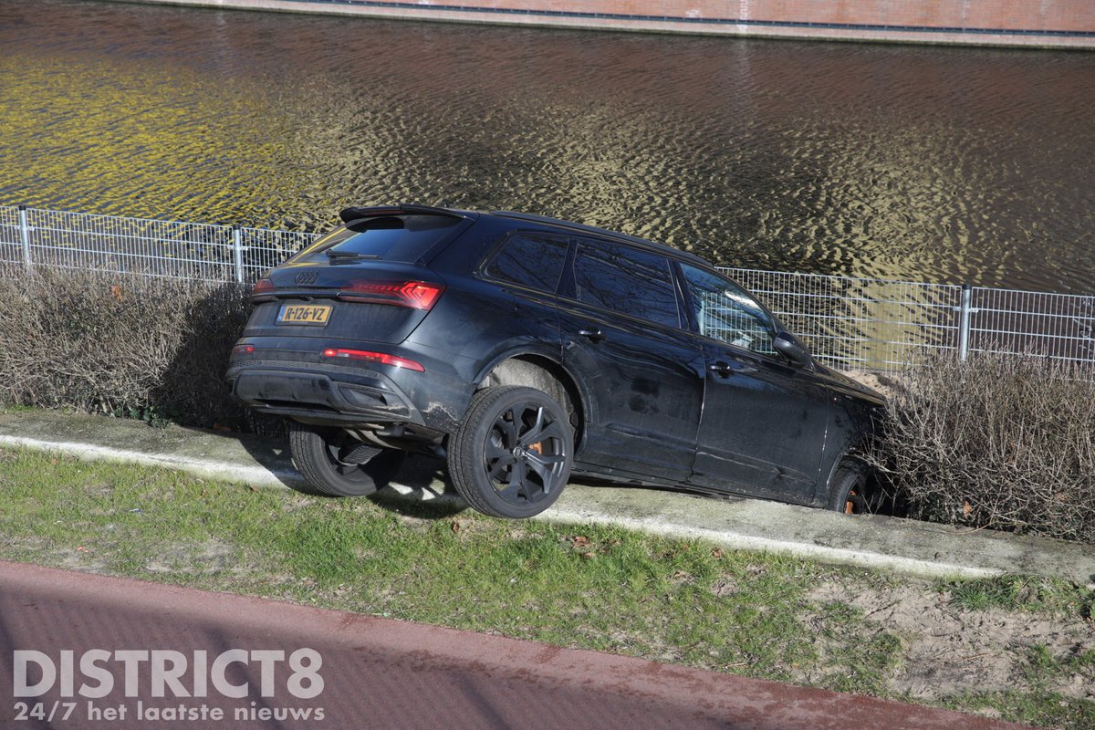 Auto rolt over rand naast sportpark in Den Haag