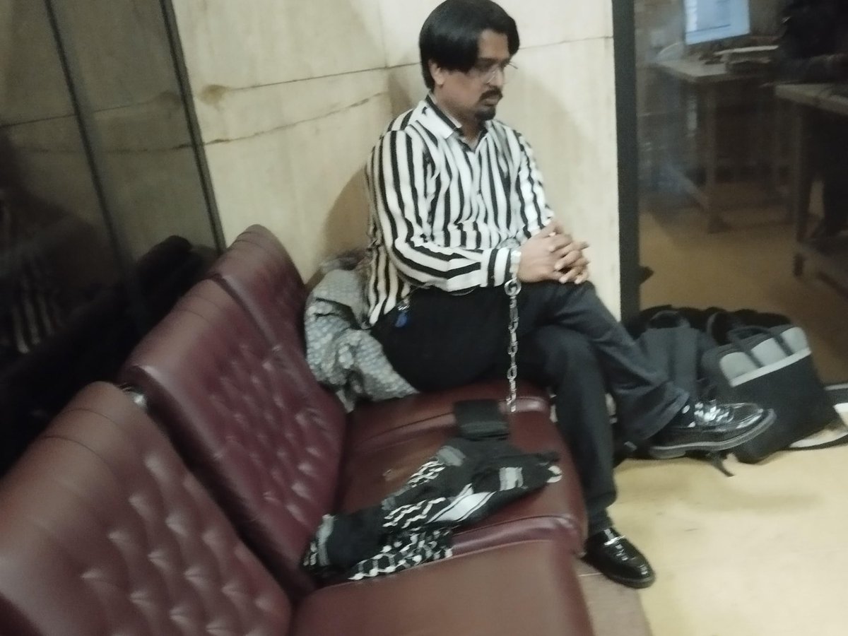 🚨🚨#BREAKING: Shocking and deplorable/condemnable picture of journalist Bilal Ghauri at the #Karachi airport after he was barred from flying to Bangladesh for election coverage, seen chained after detained by the <a href="/FIA_Agency/">Federal Investigation Agency - FIA</a> in a room at the airport.
#JournalismIsNotACrime