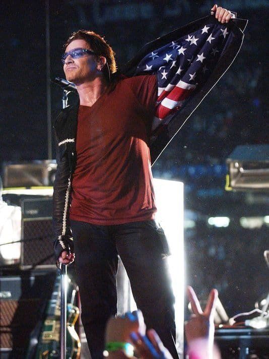 crockpics's tweet photo. Bono showing the American flag in his jacket to honor 911 victims during halftime of #SuperBowl  XXXVI, 2002. Photo by Jeff Haynes https://t.co/MmB9WYPSI9