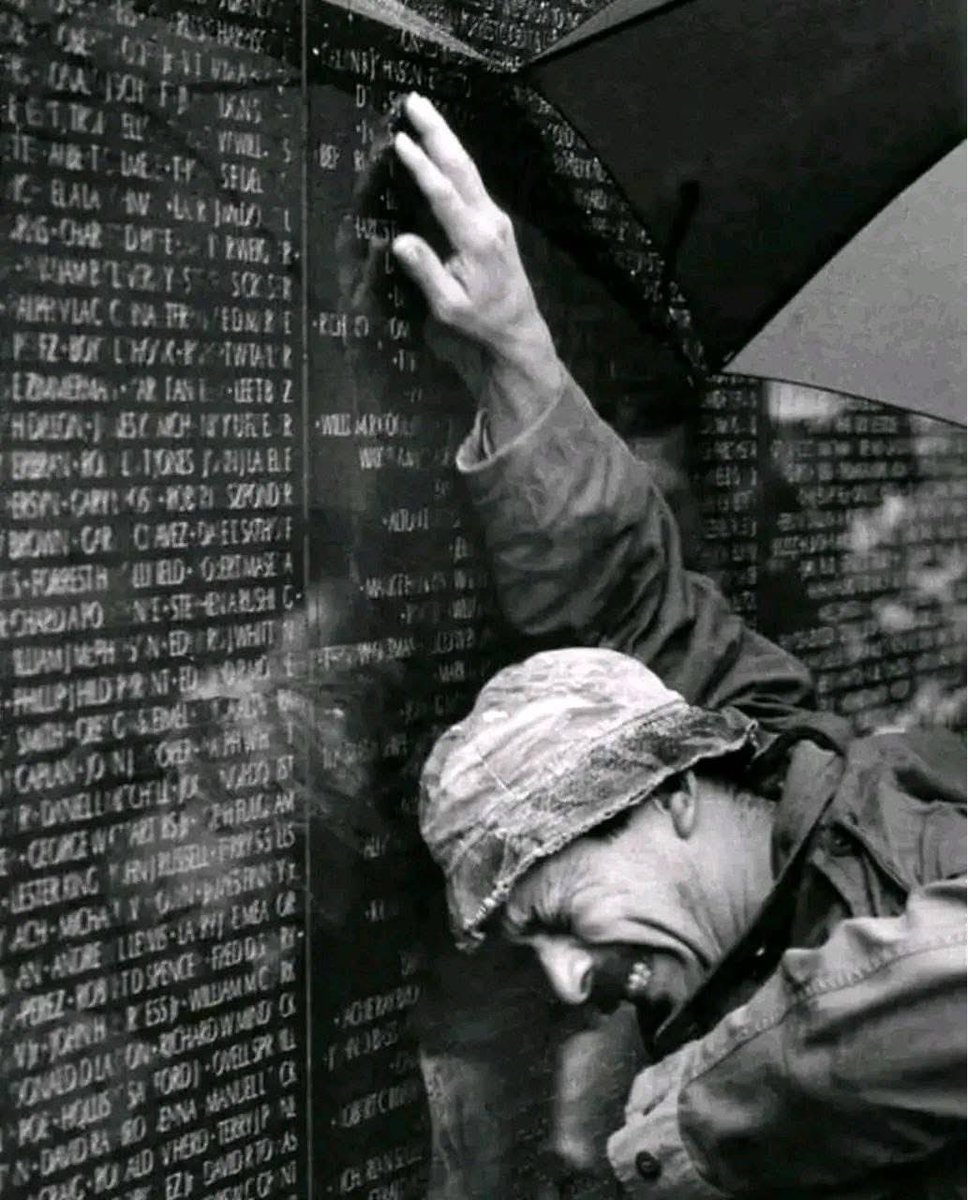 "An old man stands as straight as time allows, tears form and follow the deep lines in his face….. and he lets it go. His reflection shimmers in the black stone behind the names".

A man places his hand against the wall of the Vietnam Veterans Memorial in Washington, D.C., on