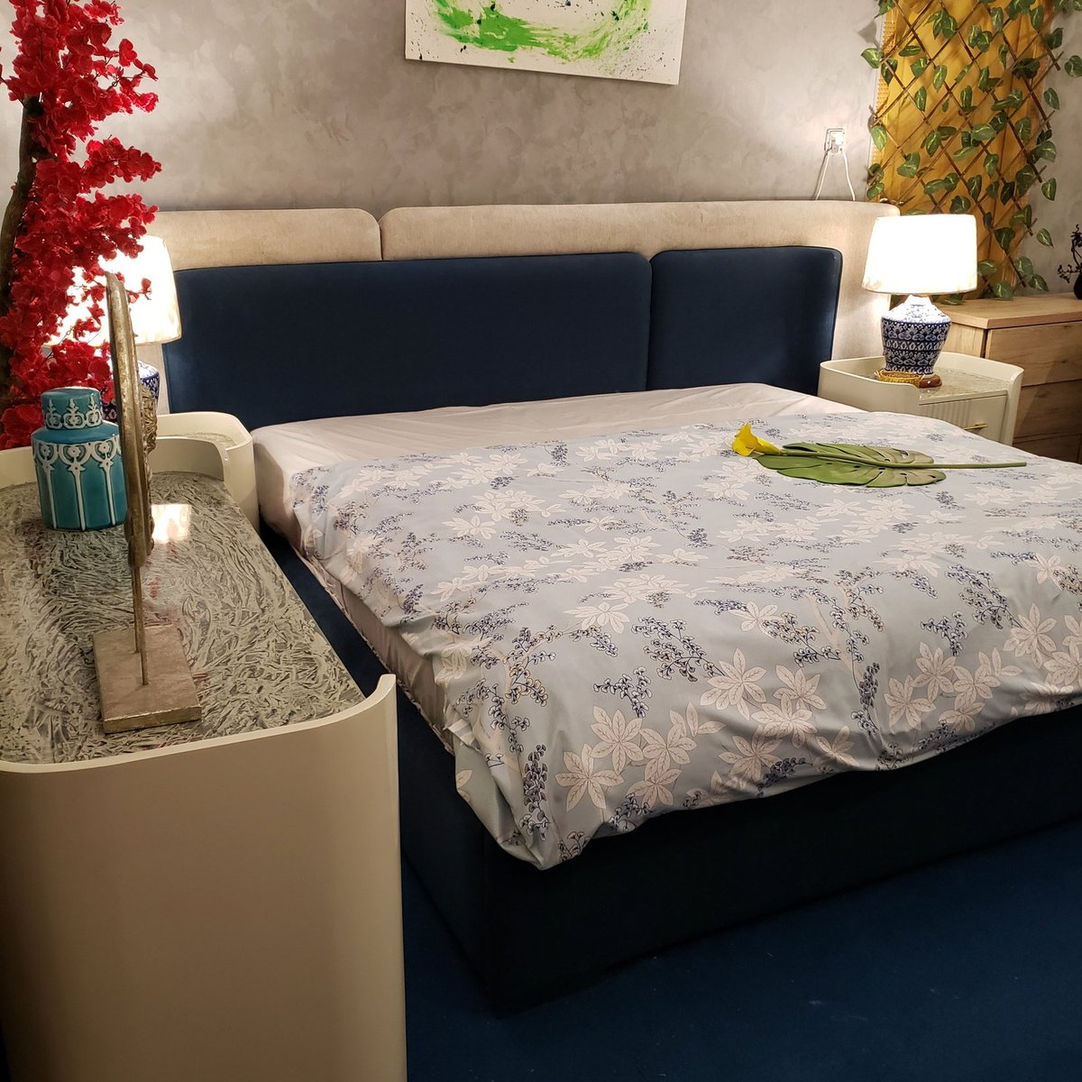 HomeFactree's tweet photo. This bed is a contemporary statement piece designed for interiors that reject ordinary layouts. The double back cushioned headboard creates layered depth, combining teal and off white upholstery for contrast that feels intentional, not trendy. The dual cushioning adds visual weight and comfort while keeping the profile clean and architectural.
The design is anchored by a white curved round side dresser that softens the structure and breaks sharp geometry. The rounded form balances the bold headboard and gives the bed a sculptural presence rather than a boxed furniture look. Every curve and color choice is deliberate, creating a setup that feels custom built rather than mass produced.
This is not a decorative bed. It is a modern composition where comfort, form, and originality are equally prioritized.