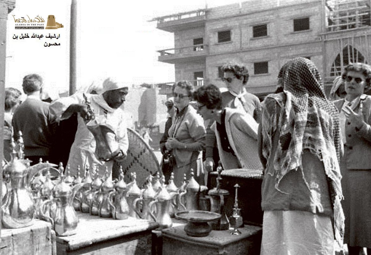 سائحات غربيات يستمعن لشرح من بائع (الدْلال) الأحسائية الأصيلة،
سوق الهفوف 1957م