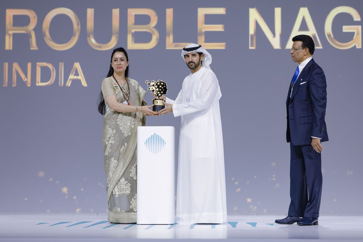 TeacherPrize's tweet photo. Celebrating teaching excellence 🏆

Rouble Nagi was announced the 2026 GEMS Education #GlobalTeacherPrize winner at the @WorldGovSummit, receiving the trophy from Dubai Crown Prince Sheikh Hamdan bin Mohammed bin Rashid Al Maktoum and Sunny Varkey, Founder of the Global Teacher Prize and GEMS Education, and Chairman of the @VarkeyFdn.

Through the Rouble Nagi Art Foundation, Rouble has transformed hundreds of learning spaces across India, giving children opportunities to learn, grow and thrive.

@GEMS_ME @roublenagi #TeachersMatter #IndianTeacher #India #RoubleNagi