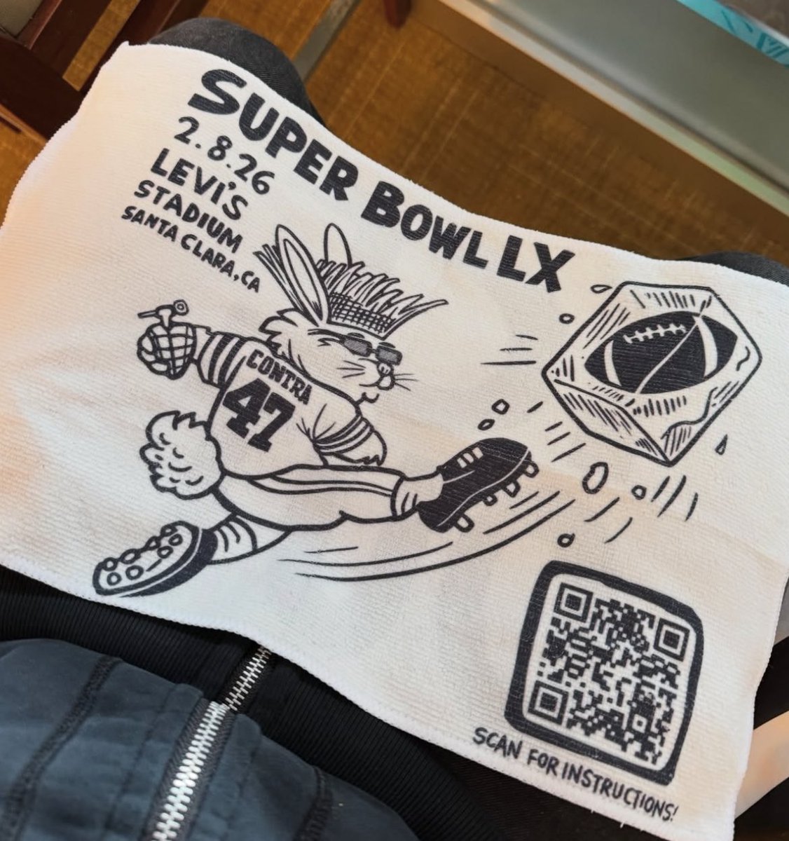 artcobat's tweet image. Durante a apresentação do Bad Bunny no Super Bowl foi distribuída essa toalha de rosto para o público. No verso, tem escrito “ICE OUT” e o QR Code leva para um site com instruções sobre o uso dela durante a partida. A ação era pra que, cada vez que o árbitro sinalizasse uma…