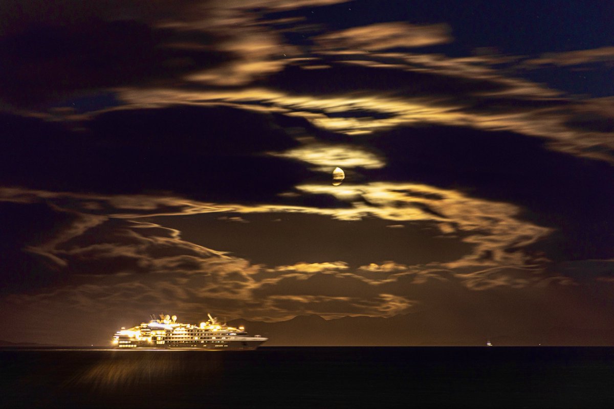 Bahia Ushuaia, barco antártico esperando entrar a puerto, luna menguante entre nubes, un paisaje para sentirse bien.