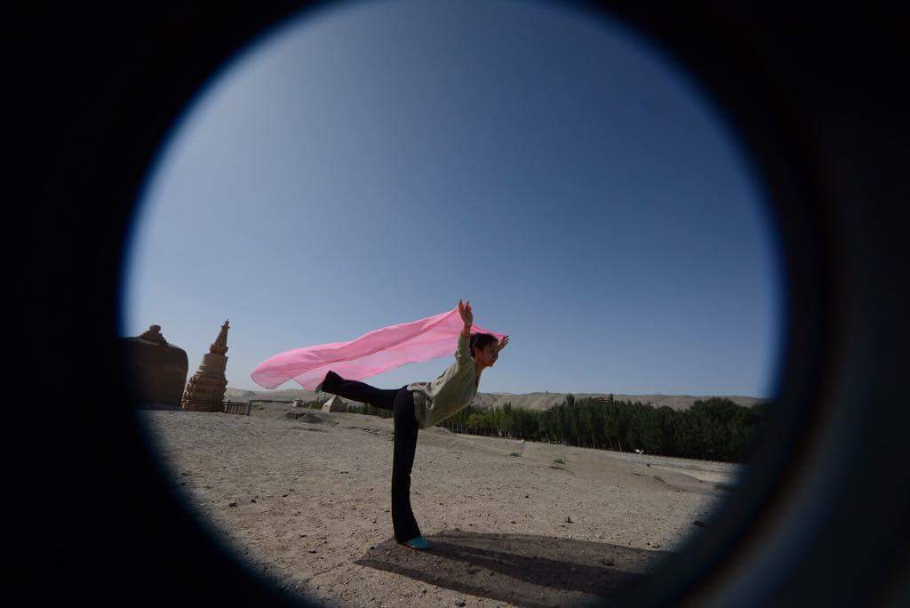 Arts_SpaceNews's tweet photo. Flo Li, San Diego, from Xi'an China, doing a Yoga Warrior Stance on The Silk Road. The Gobi Desert is in the background. Model for Frank Seidl's "Alchemist Series" Twin Cities Minnesota. https://t.co/g9zVvuJM8l