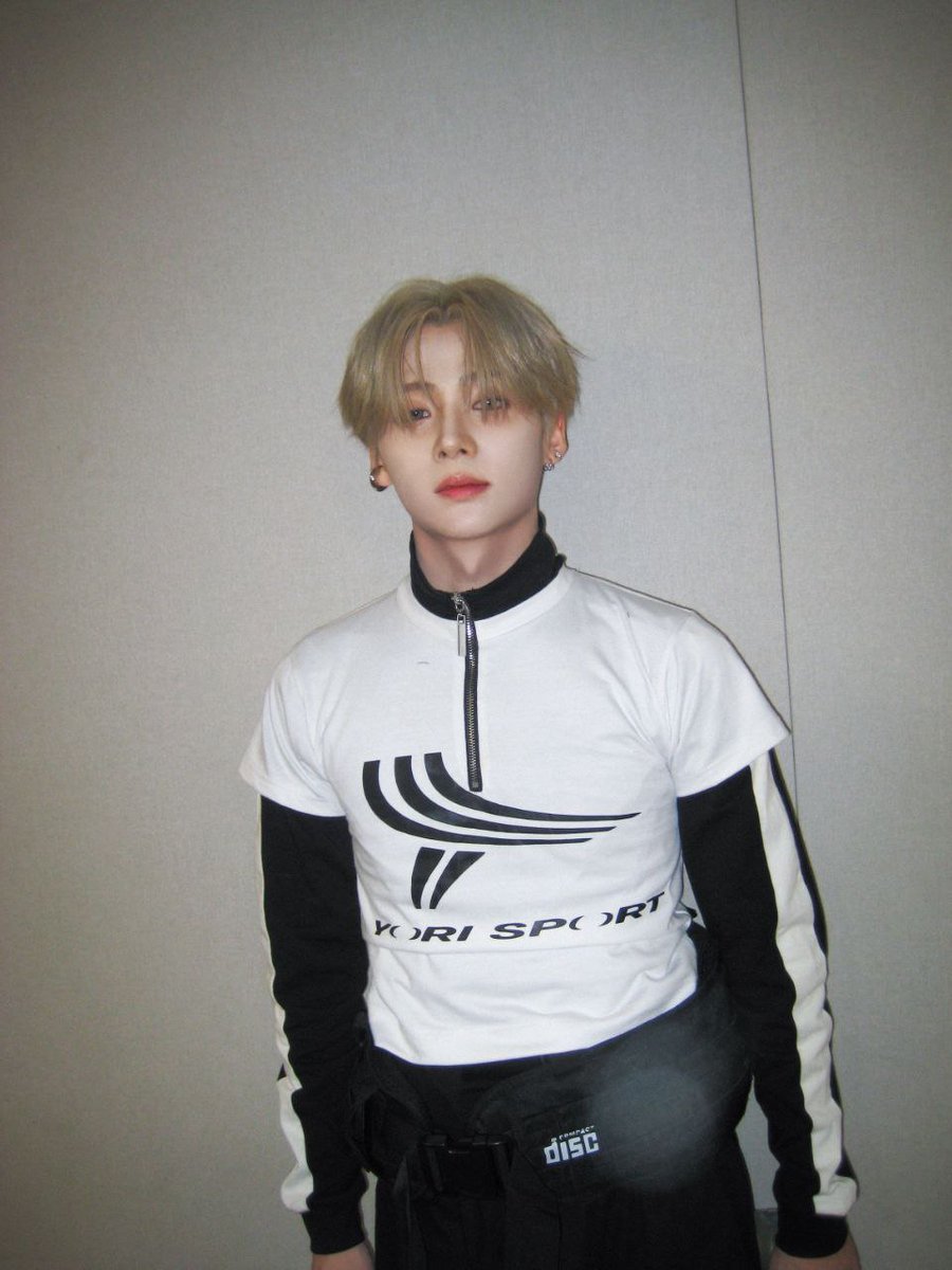 ᅠ
Ash-blond halo, porcelain poise—he stands in monochrome cadence, ivory zip and obsidian sleeves tracing a sleek silhouette. Sport turned sculpture, softness edged with steel; a quiet comet in minimalist light.
ᅠ