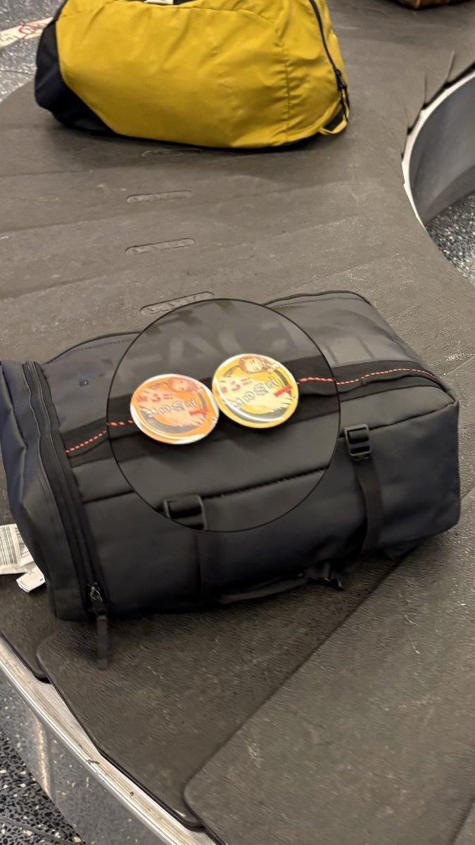 飛行機の荷物受け取りの時に見覚えのある缶バッチ発見🌻