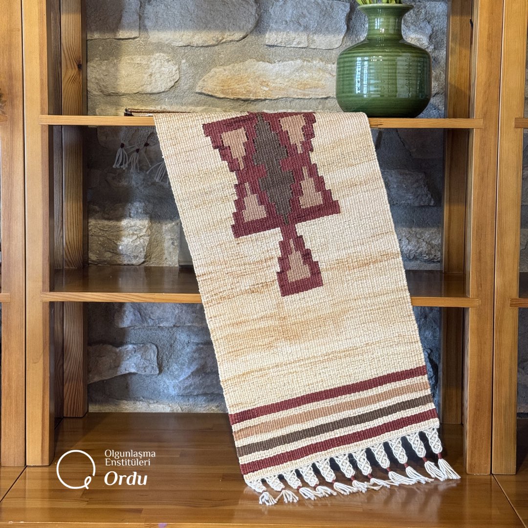 Alan taramalarımız sırasında Gölköy ilçesi Kozören Köyü’nde tespit edilen geleneksel kilim desenlerinden esinlenerek, mısır kabuğu kullanılarak Enstitümüz dokuma atölyesinde kilim tezgâhında ördüğümüz masa örtüsü, doğal malzeme ile kültürel motif dilinin buluştuğu özgün bir