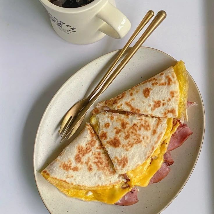 —Le alcanza un plato y una taza de café como para que coma algo.—