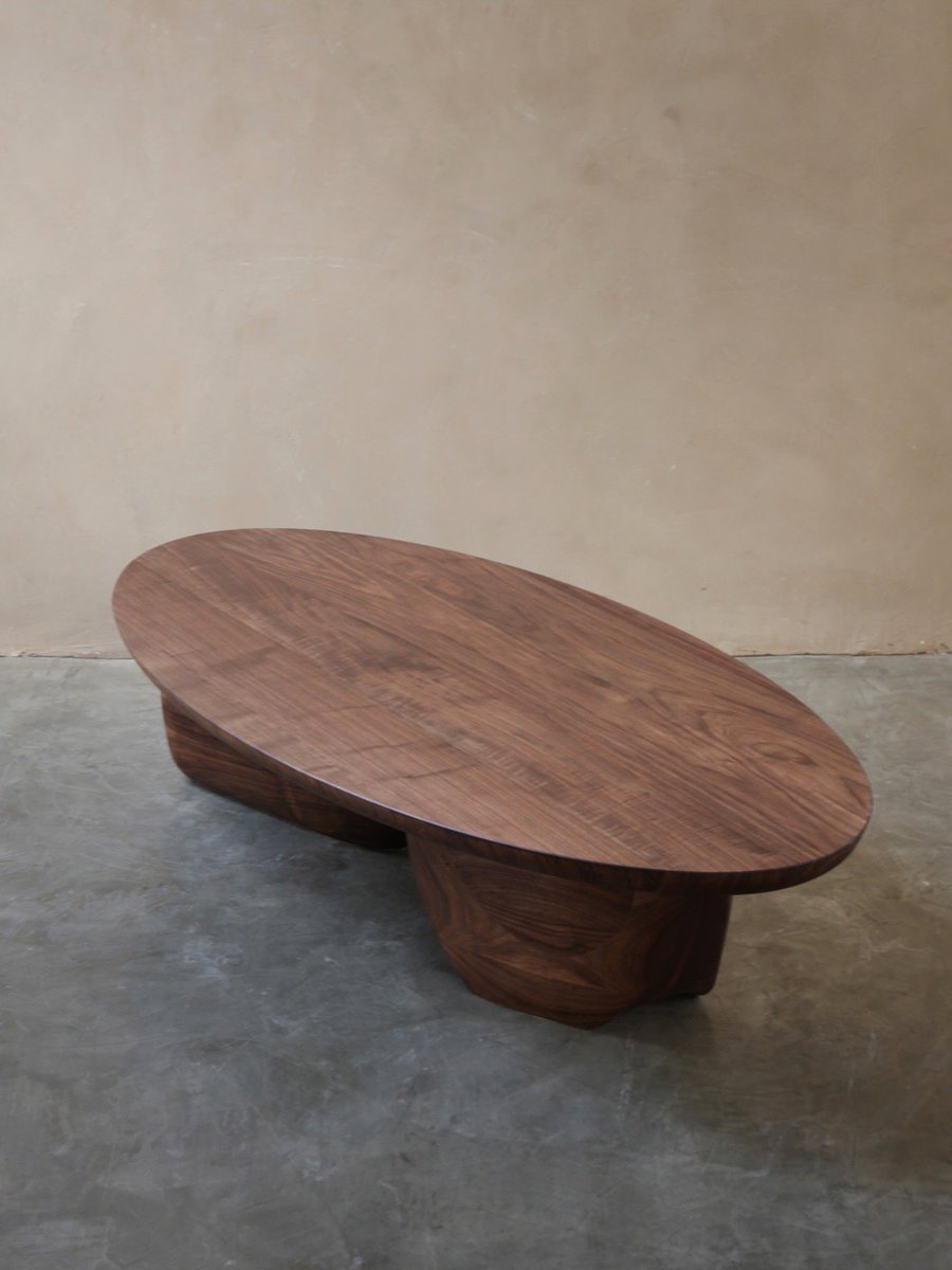 In a lived room, the coffee table takes the first hit. Keys, books, cups, elbows. It should accept that friction. The surface needs to feel honest under the hand, not precious.