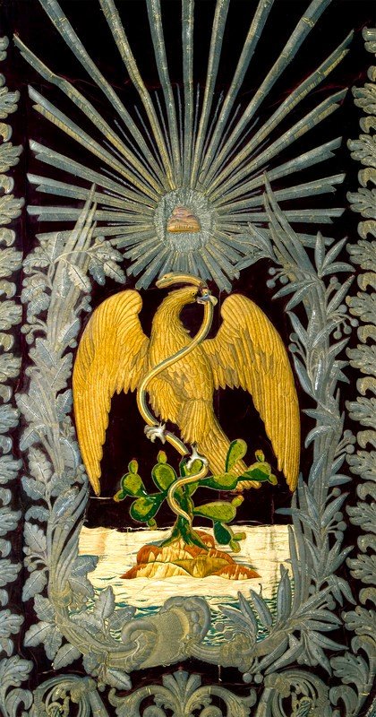 #PiezaDelDía 🇲🇽 Pendón

Bandera bordada sobre textil que exhibe, al centro, un águila real dorada posando sobre un nopal mientras devora una serpiente. Fue elaborada entre los años 1857-1861.