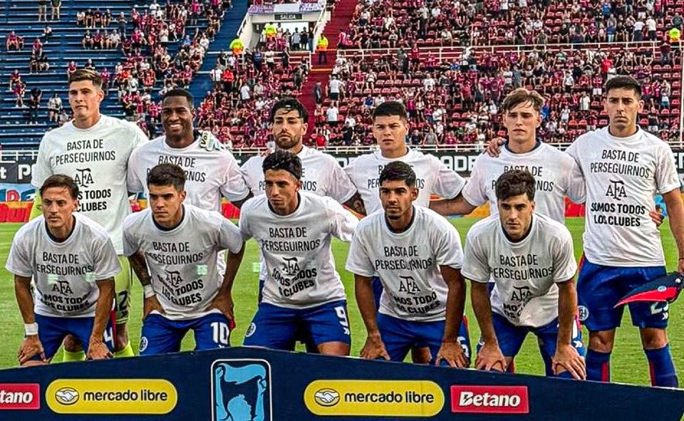 A los jugadores de San Lorenzo los obligaron a salir con esta remera para posteriormente chorearles de la manera mas descarada q yo haya visto en el ultimo tiempo. El futbol argentino se nos muere en las manos