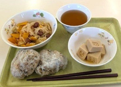 minakenbo's tweet photo. 「食べることは生きること、作る力は生きる力。 「生きる力」を育む、泉大津市の食育の取り組み〜就学前施設」

🟠その1
泉大津市の公立園では、おやつにもこだわっています。令和7年度からは米粉入りの「おづみんパン」を月2回提供しています。おづみんは泉大津市のマスコットキャラクター。
おづみんパンは、こどもたちに安心でおいしいおやつを届けたいという想いから、食育アドバイザーの中塚由子さんや洋菓子のお店「FLOUR（フラワー）」と、本市との連携によって誕生しました。

原材料にこだわり、小麦粉には北海道産の「春よ恋」、砂糖にはきび糖、油は米油を使用し、添加物を使用せずに作られています。また、1歳児でもかじり取りと咀嚼ができる硬さになるよう、小麦粉と米粉の割合を変えながら試作を繰り返し、ようやく完成した特別なおやつです。

こどもたちがより親しみを持ち、楽しみながら食に触れられる機会になることを願っています。

🟠その2
栄養価の高い金芽米と、和食を中心とした給食。
すべての公立園と一部の民間園の給食では、栄養価の高い「金芽米」を使用。金芽米は精白米に比べ、ビタミンB₁や食物繊維が多く、腸内環境の改善や、免疫力の向上につながります。
また、副食は和食中心の献立とし、有機野菜や地元の野菜を積極的に取り入れています。こどもたちの健やかな成長へとつなげています。
なお、これらの米や野菜については、泉大津市と農業連携協定を締結する全国の農山村地域の自治体から提供を受けています。また、地元で特別栽培された農産物も使用しています。

🟠その3 
子どもたちの自分で作る力と五感を育む。
公立園の5歳児が、将来の自立した自分への架け橋となることを目的とした、給食の調理体験を実施しています。昆布とかつお節で出汁をとるところから始まり、出来たての出汁を味見したり、切干大根の匂いを嗅いだりと、五感を使っておこなうクッキング。こどもたちにとってたくさんの発見があります。

🟠その4
保護者のきがるにクッキング。
日々の仕事や家事、育児に追われている保護者に、ホッと一息つける時間を提供したいという想いと、気軽に参加して食の良さを感じてほしいという想いから、公立園の保護者を対象に始まった取り組みです。
料理が苦手な方も、おしゃべりしながら楽しくクッキングされており、「参加してよかった」との声を多くいただいています。

泉大津市では、市民の「食の自立」の実現に向け、乳幼児期から食に触れる機会を重ね、自炊できるこどもたちを育て、家庭で無理なく楽しみながら続けられる食の取り組みを広げていきます。