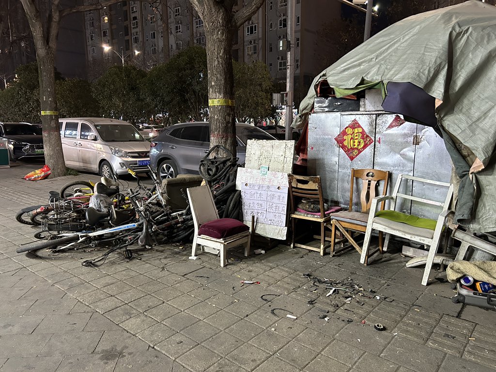 MadForMaple's tweet image. The clutter of a roadside bicycle 🚲 repair stall in Xi'an #China. Closed HK for the evening! During the day it's a busy place. Not tidy, but busy! #bikes #cycling