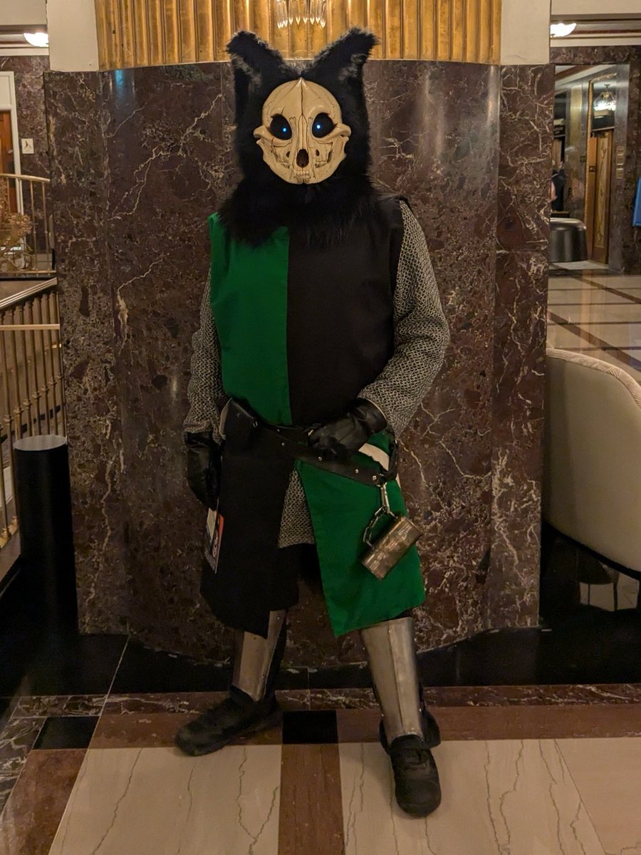 ZManCosplay's tweet photo. Being invited to con with a medieval / renaissance theme is an excuse to make a new surcote.

It's sized/lined for wearing real mail, which also can cause the neck fluff to poke out. 

Yes. The "sword" is a bone.

Skull Base: 
@DvC_Ciara

#cosplay #FursuitFriday #fursquared2026 https://t.co/CeYvmu4UCm