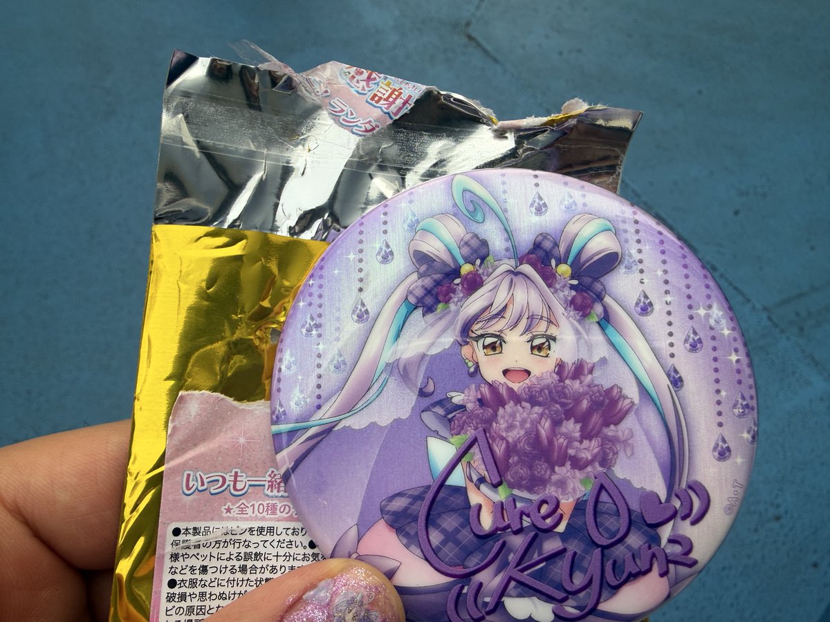物販で缶バッジ1個だけ買ったら、反射して中の銀の包み紙に紫色が見え