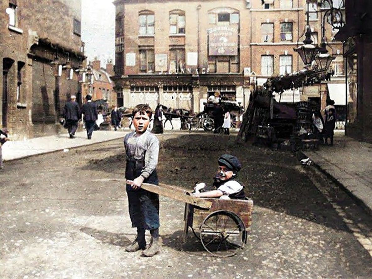 Two boys play on the street in London's East End in the early 1900s.
