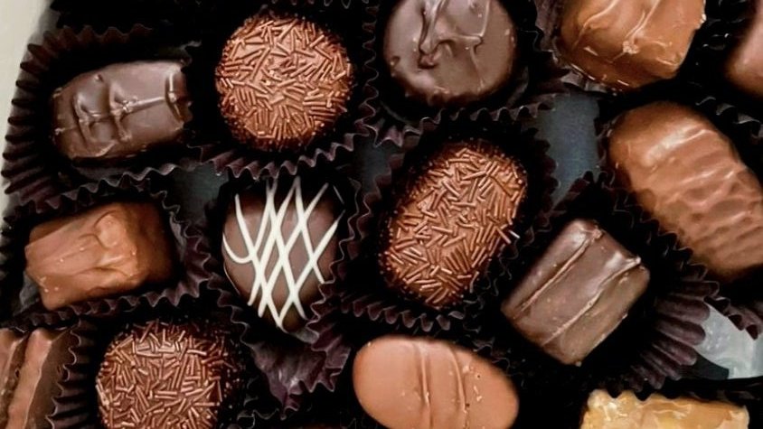 <a href="/99DSTRCTs/">DISTRICT:99.</a> ️️ ️️ 
️️ ️️ 
Kotak dibuka perlahan hingga deretan cokelat praline mengilap itu terlihat jelas—sempurna. Tangannya menahan kotak sedikit lebih tinggi agar semua orang bisa melihat.

“Silakan pilih sesuai selera. Boleh coba lebih dari satu.”
️️ ️️ 
️️ ️️