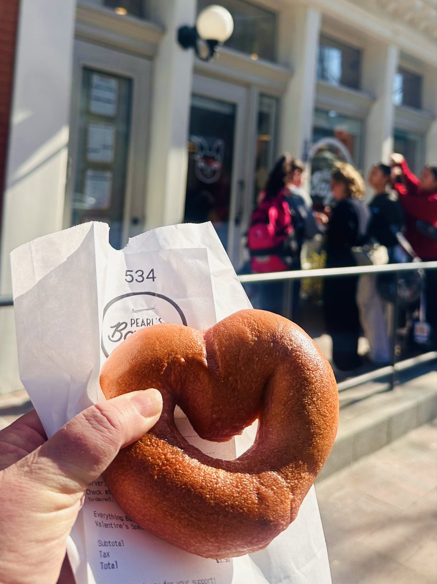 I snagged the heart‑shaped bagel from <a href="/pearlsbagels/">Pearl's Bagels</a> and it’s just as fun (and delicious) as it looks! The shop was packed today — Valentine’s Day plus a whole volleyball tournament across the street at the Convention Center. Only in 2G06! 🥯💕