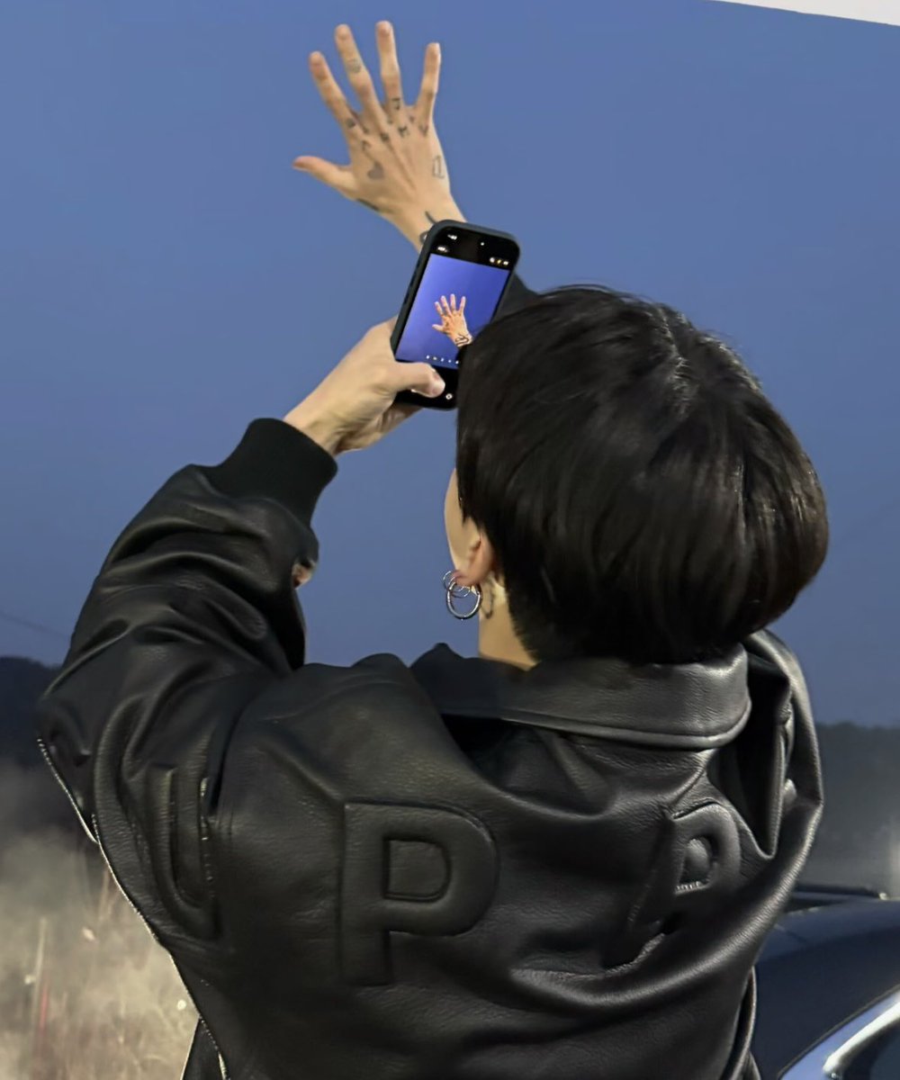 dreamjeons's tweet image. jungkook taking a picture of his tattooed hand and the sky 😭🥹