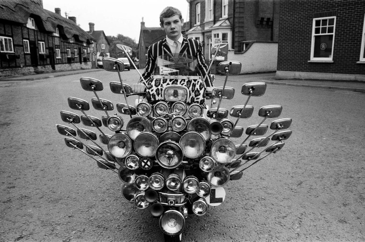 HistoryUnd's tweet photo. Bryn Owen aged 17 with his Vespa scooter, which has 34 mirrors and 81 lights on the front and back, all bought with his pocket money, Leicestershire, England, 1983 https://t.co/Ce2YblDRvT