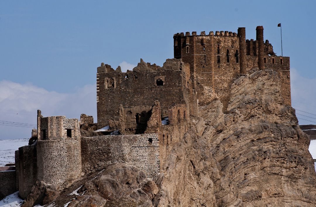 Doğu Anadolu’da, sert coğrafyanın ortasında yükselen Hoşap Kalesi, yüzyıllardır ayakta kalan etkileyici yapılardan biri. Van’a bağlı Hoşap (Güzelsu) beldesinde yer alan kale, bulunduğu konumla hem savunma hem de hâkimiyet açısından stratejik bir noktada yükseliyor.