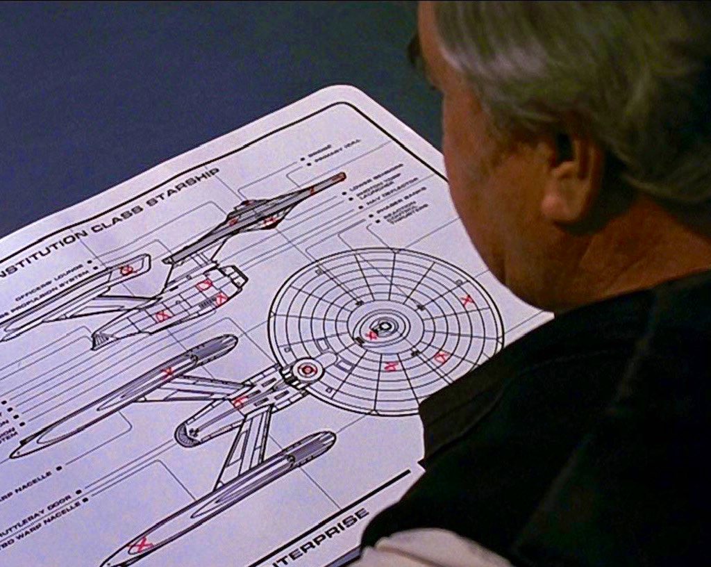 Scotty diligently marking in red the places on board the Enterprise where he has hidden bottles of booze
