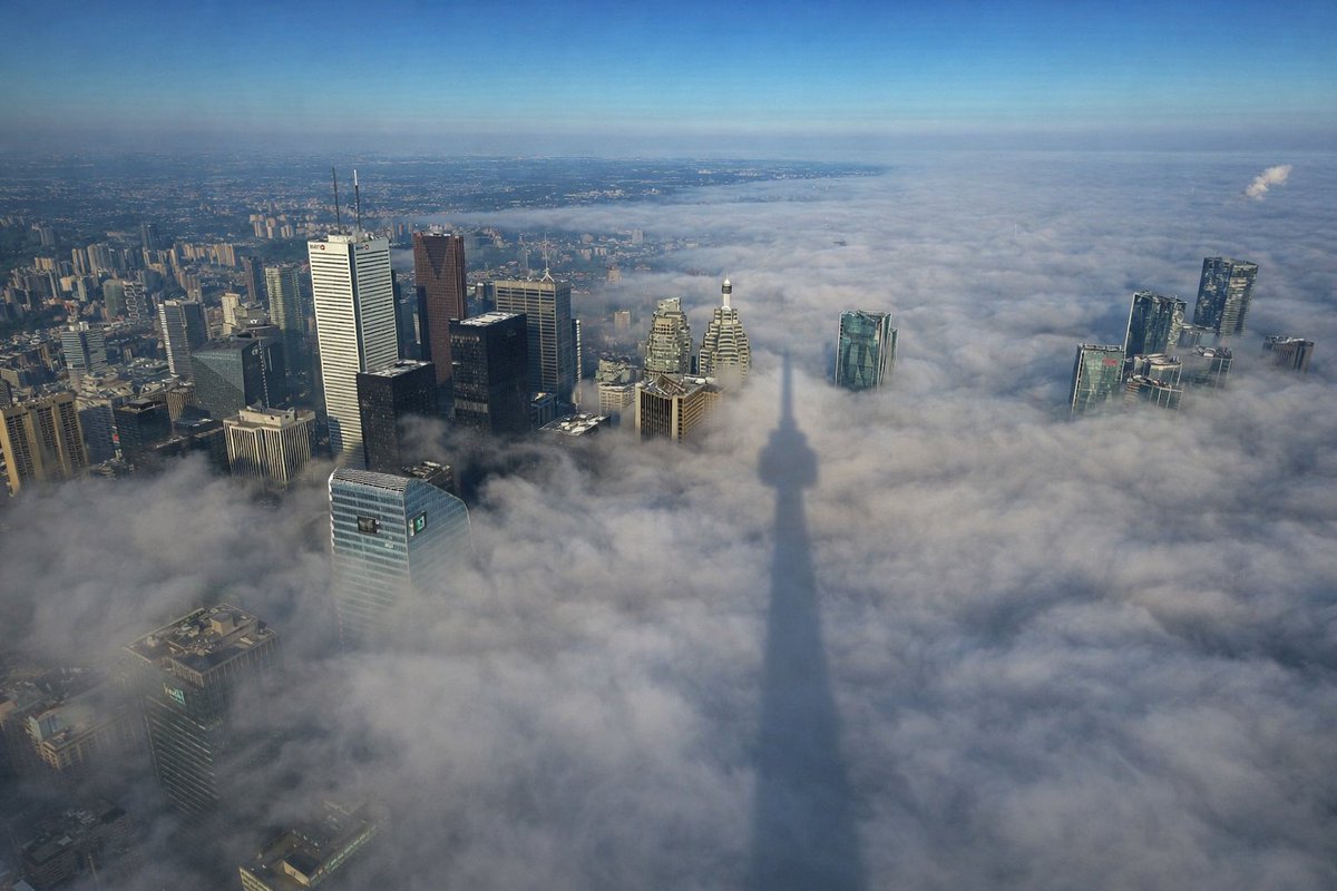 Thick fog rolls into Toronto, causing the CN Tower to cast a massive 3 km shadow across the downtown core 🇨🇦👀