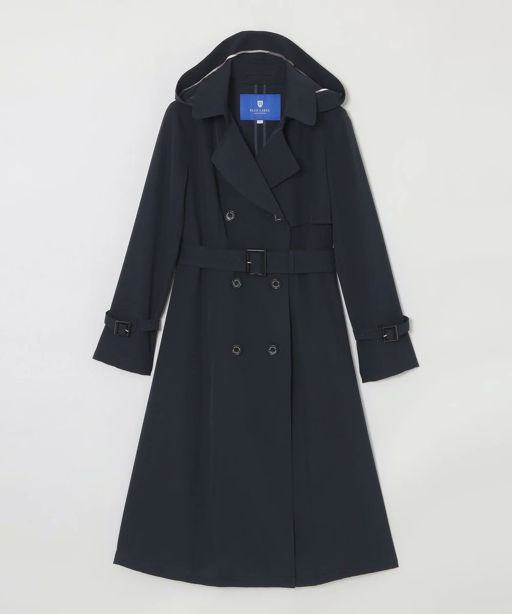 落ち感のある素材を使用したトレンチコートは、ボタンを留めてベルトを