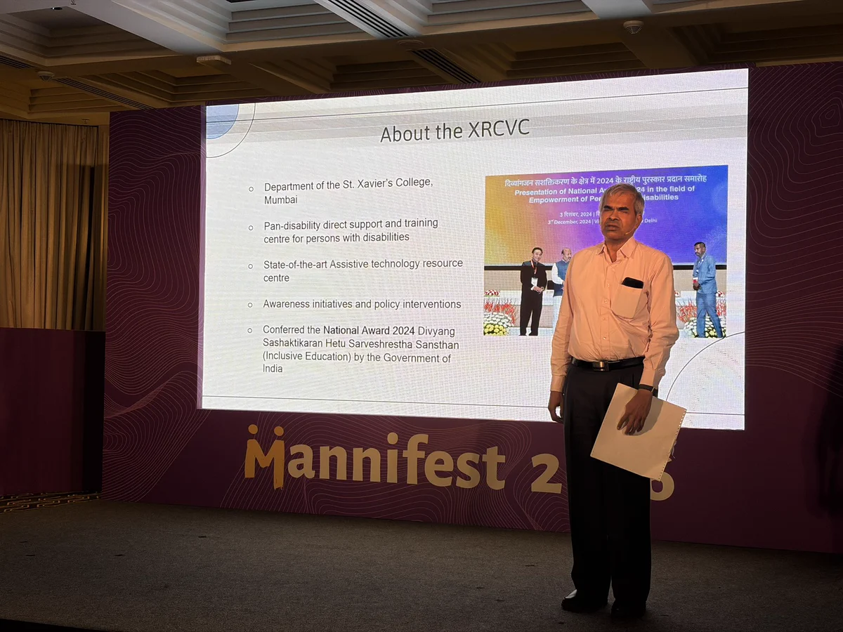 Ketan Kothari standing in front of a presentation explaining and teaching about accessibility and assistive technology.