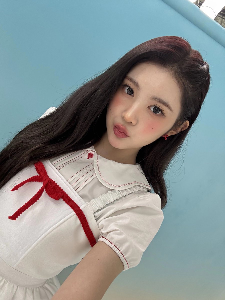 Behind the soft glow of the camera, I sit in the quiet before the storm—lace, ribbons, and a heartbeat wrapped in anticipation. In this still moment behind the scenes of RUDE!, innocence and edge intertwine, like a red ribbon tied gently around something ready to break free.