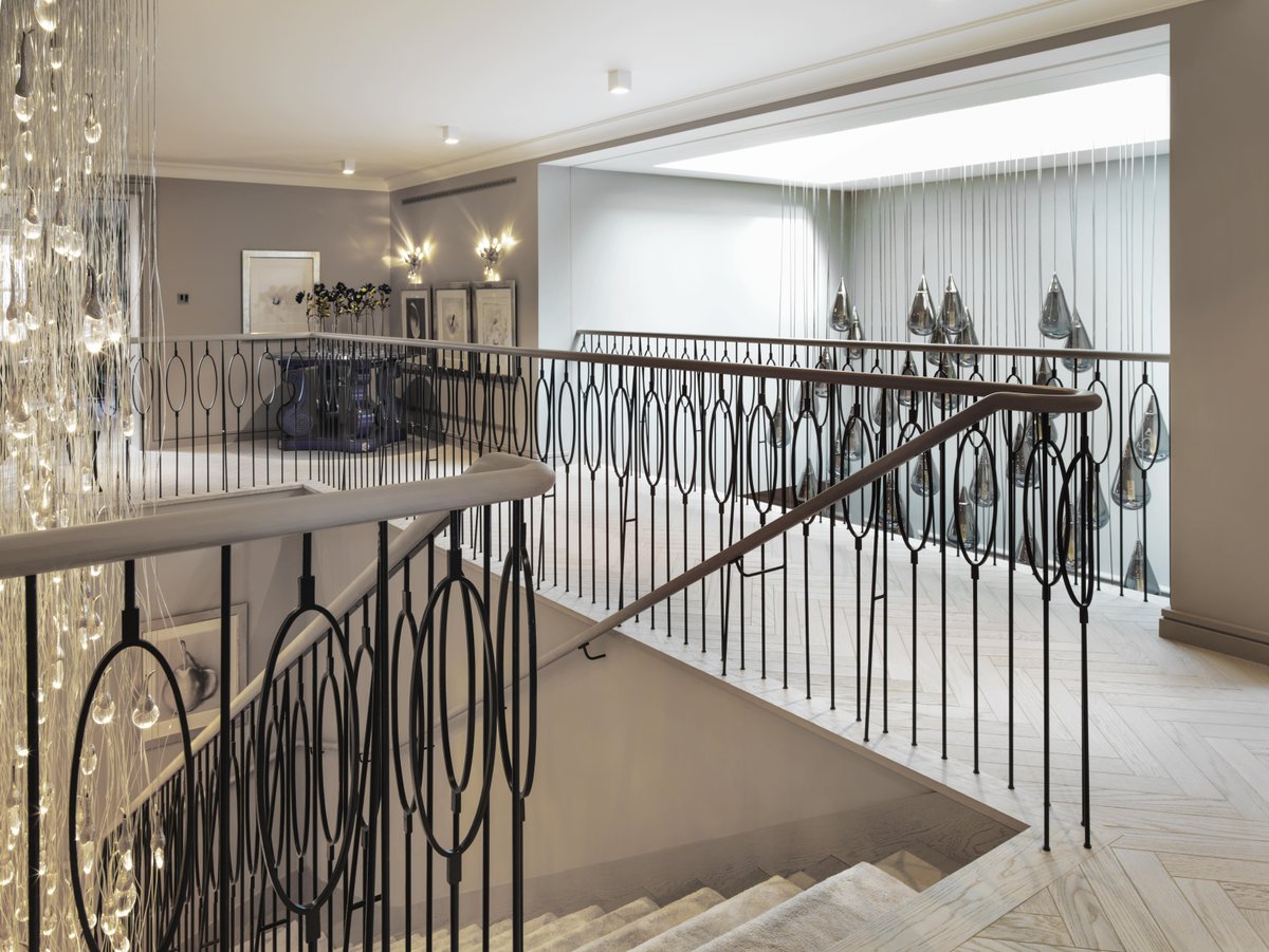 kellyhoppen's tweet photo. A staircase is the spine of the house, so it needs presence. A full-height cascade of glass draws you up through the space, while the wall lights sit above the beautiful artwork. Custom lights by Ochre #staircase #lighting #interiordesign https://t.co/qQsPI9qPDs