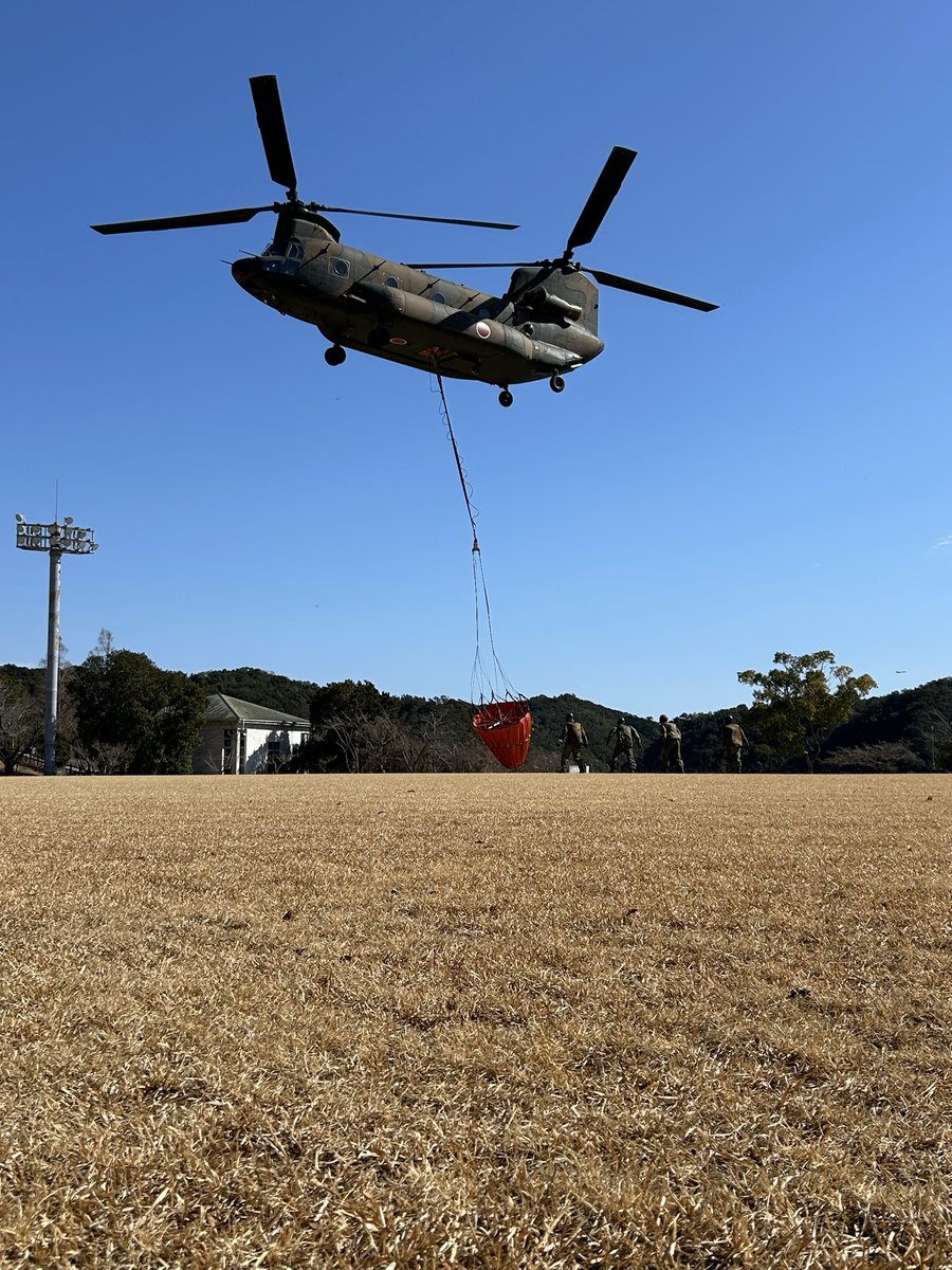JGSDF_YAO's tweet photo. 【#災害派遣】
中部方面航空隊は ＃徳島県 那賀郡で発生した、＃山林火災 に対し災害派遣要請を受け、大型ヘリコプター（CH-47）により空中消火活動を開始しました。

写真は、機体の下部にバケットを装着し取水点に向かう様子です。

#自衛隊　#即応 https://t.co/EByKW3dWmU