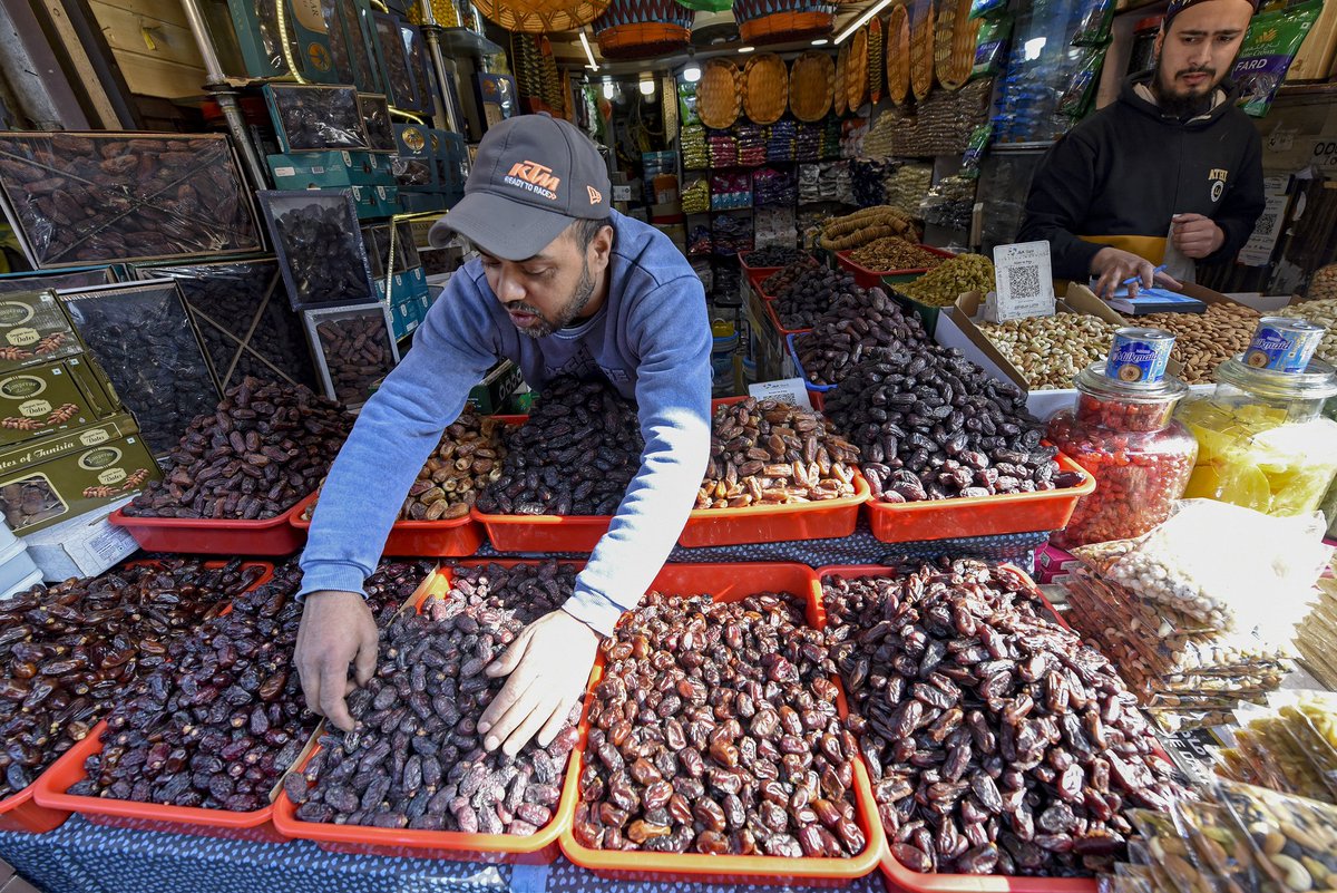 People buy dates and dry fruits at a local market in preparation for the holy month of Ramadan in Srinagar.