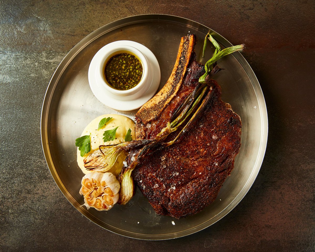 Experience the rich, succulent flavors of our Prime Bone-in Ribeye (18 Oz). Served with charred knob onion, scallion soy, roasted whole garlic and bearnaise for a culinary adventure! 🥩🍴#TheFranklinRoom #RibeyeRevelation
