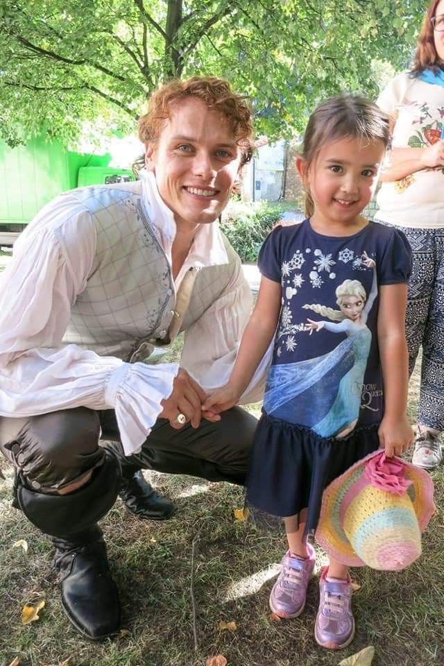 point_blank1959's tweet photo. Jamie with children bts. In (1) like an Ogre (after the fight with the Tskili Boo Bear). In (2) being taken for Prince Charming by that little girl- she was kinda right. ( in Prague filming for Season 2). #SamHeughan #Outlanderbts https://t.co/UM0ESHgKql
