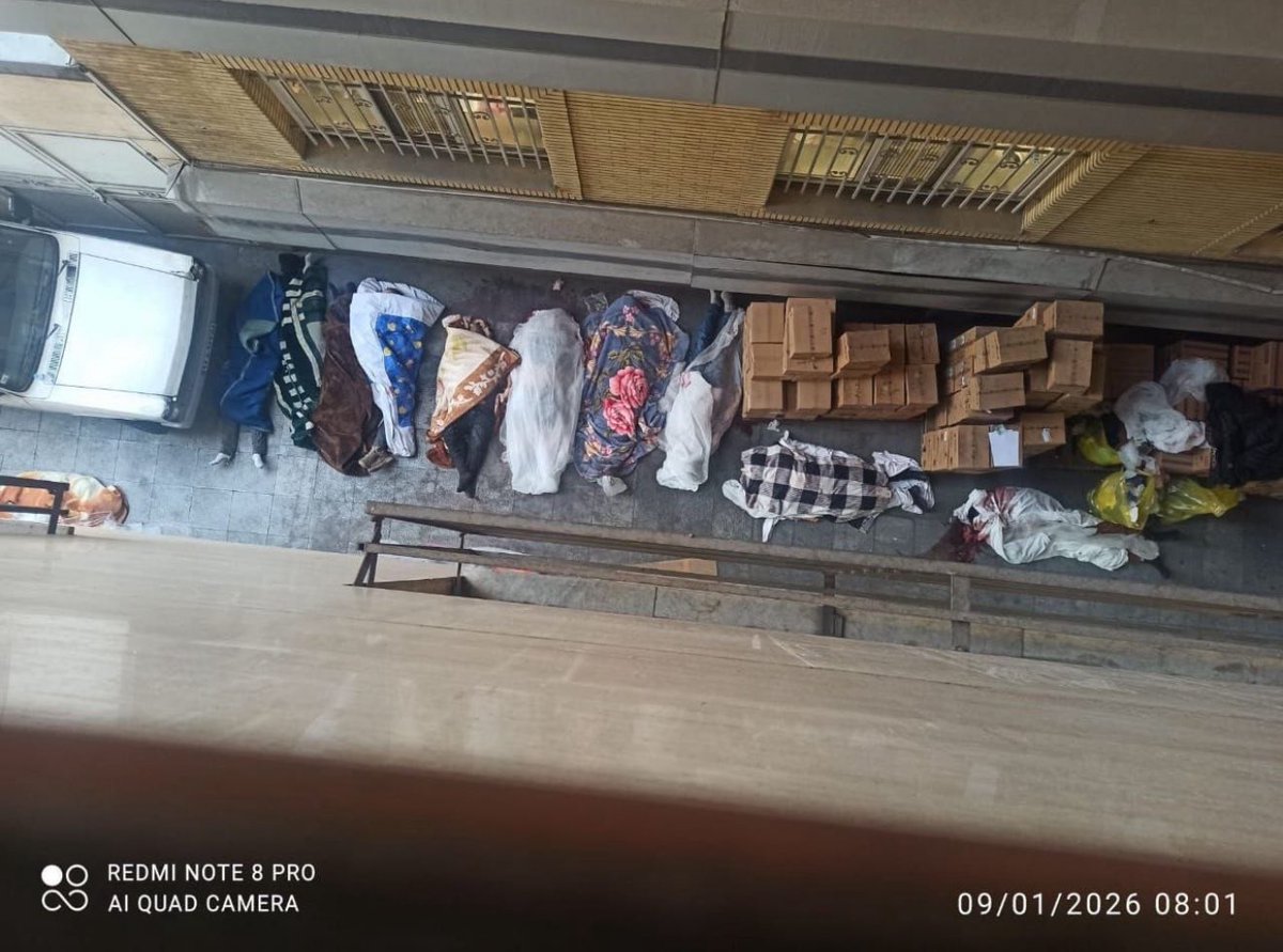 این تصویر از فضای داخل بیمارستان الغدیر است.
یکی از مهمترین اسناد کشتار مردم در ۱۸ و ۱۹ دی ماه.
رها کردن کشته‌ها، این چنین در پستوی بیمارستان و در میان کارتن‌ها و زباله‌های بیمارستان.
تصویری روشن از جنایتی هولناک‌. تصویری که نشان می‌دهد کشته‌ها فراتر از ظرفیت بیمارستان برای