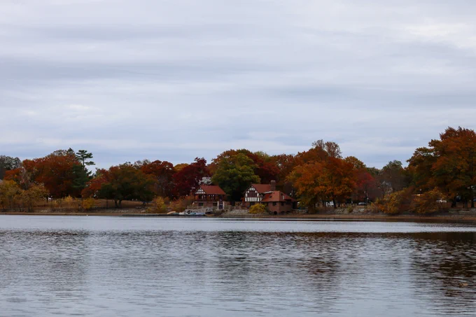 Image of Jamaica Pond in the fall, with the Boathouse and the Bandstand building on the shoreline.